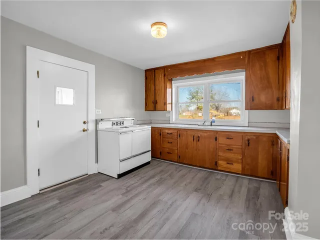 a kitchen with stainless steel appliances sink cabinets and wooden floor