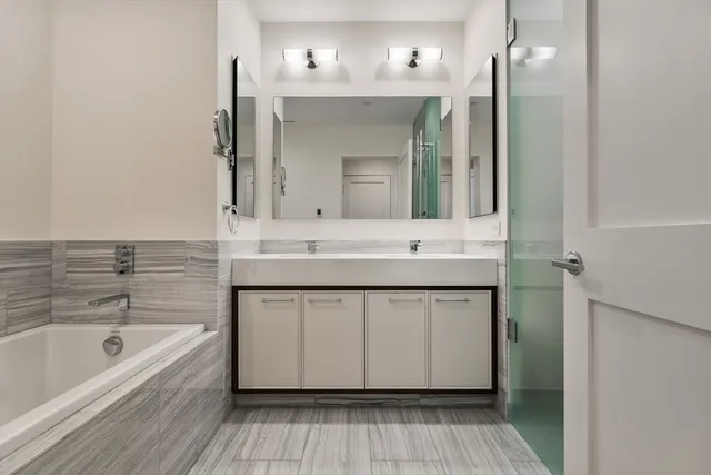 a bathroom with a sink double vanity granite tub and shower