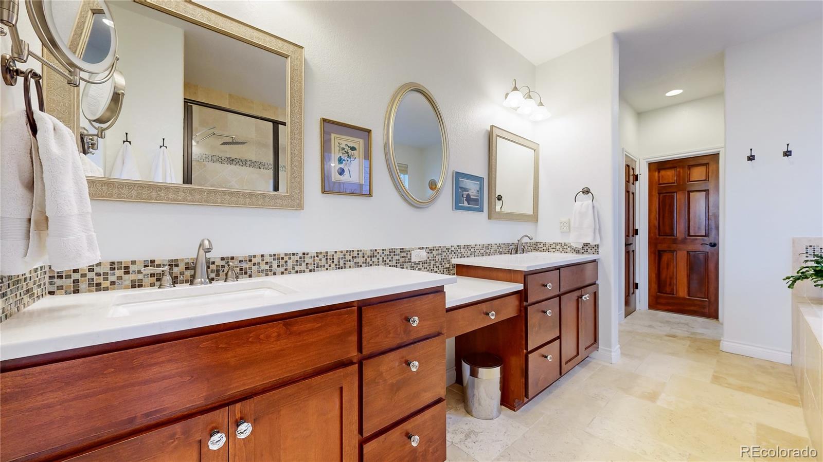 8400 Quaker Circle Arvada, CO 80007 - Photo 21 of 50 a spacious bathroom with a double vanity sink and a mirror