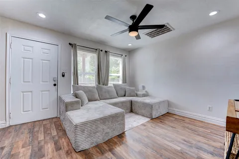 a living room with furniture and a wooden floor
