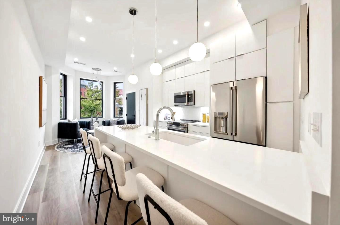 a large kitchen with kitchen island a large island a sink appliances and a table