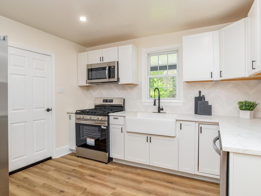 1660 Mercer Road Ellwood City, PA 16117 - Photo 14 of 41 a kitchen with stainless steel appliances granite countertop a stove a sink and white cabinets