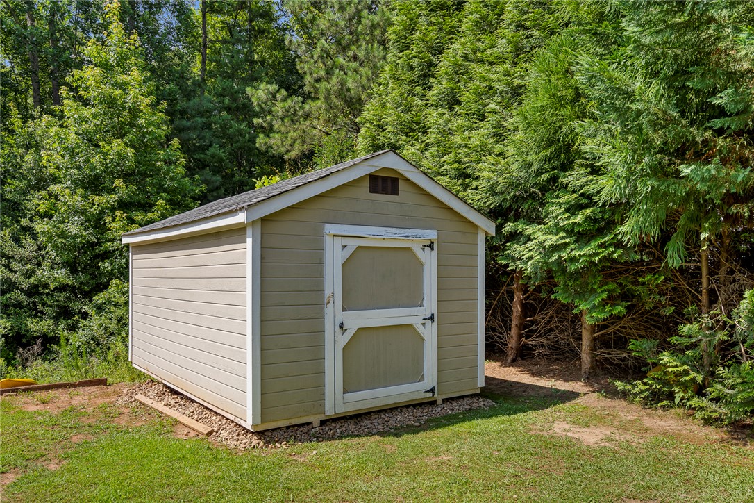 167 Mediterranean Avenue Anderson, SC 29621 - Photo 30 of 33 A quaint storage shed offers convenient organization amidst a lush, private landscape.