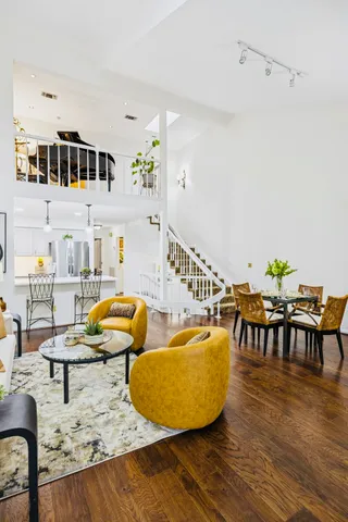 a living room with furniture a rug potted plant and a window