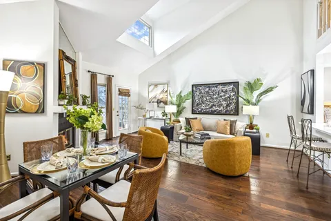 a dining room with furniture potted plants and wooden floor