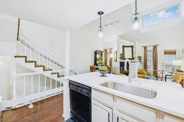 a kitchen with a sink stove and wooden floor