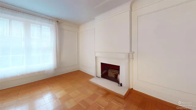 a view of an empty room with a fireplace and a window