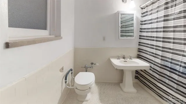 a bathroom with a sink a toilet and mirror