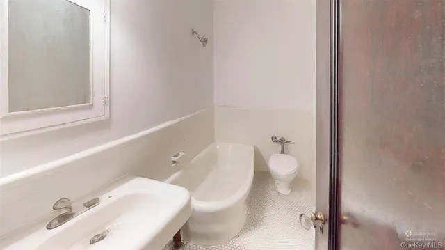 a bathroom with a toilet a sink and mirror