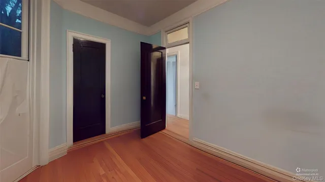 a view of hallway with closet and wooden floor