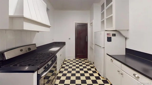 a kitchen with granite countertop a stove and a refrigerator