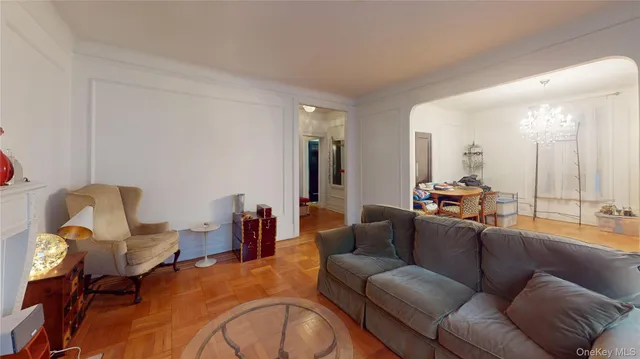 a living room with furniture and a large mirror next to a window