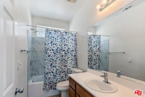 a view of a backyard with couches plants and wooden fence