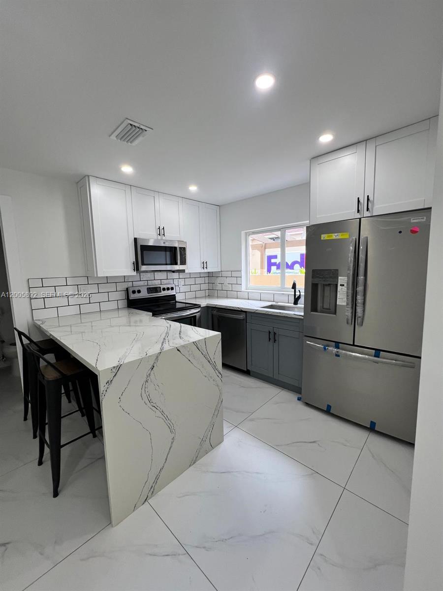 3632 Southwest 112th Avenue, Unit 63 Miami, FL 33165 - Photo 5 of 14 a kitchen with stainless steel appliances granite countertop a stove refrigerator and a sink
