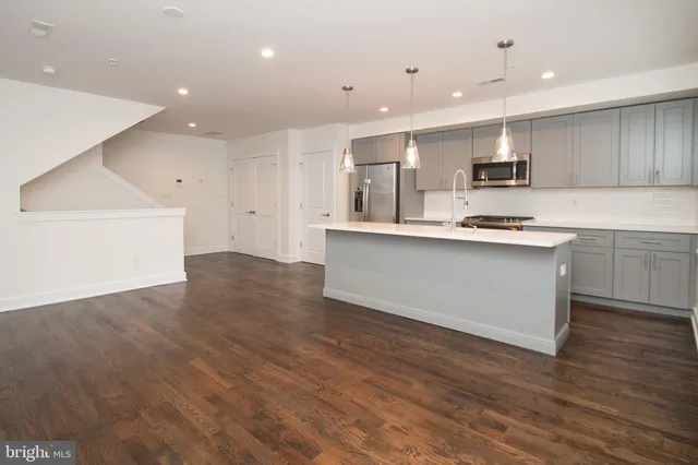 a kitchen with stainless steel appliances kitchen island granite countertop a sink and cabinets