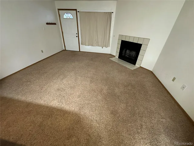 a view of a livingroom with an empty space and a fireplace
