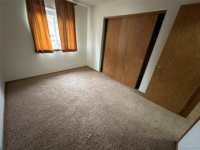 an empty room with windows and closet