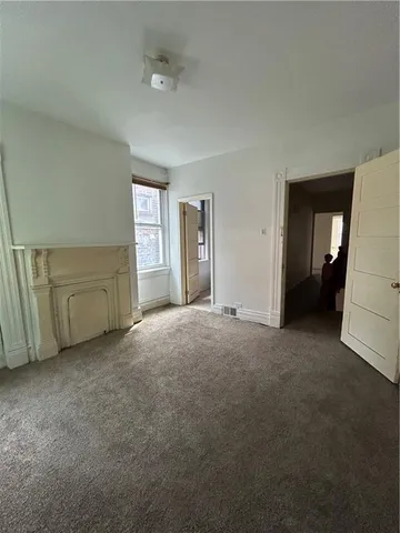 a view of a livingroom with an empty space and a window