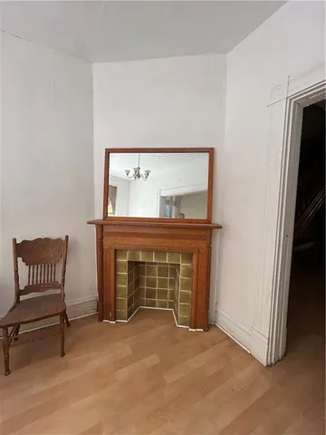 a view of an empty room with a fireplace and a window