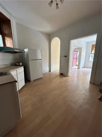 a view of a livingroom with fridge and workspace