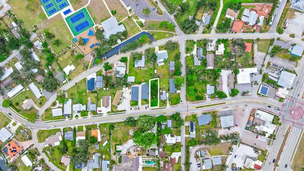 an aerial view of residential houses with outdoor space and trees