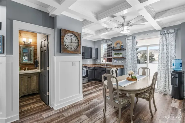 a kitchen with granite countertop stainless steel appliances a dining table and chairs