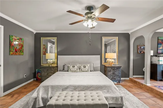 a bedroom with a large bed and a chandelier
