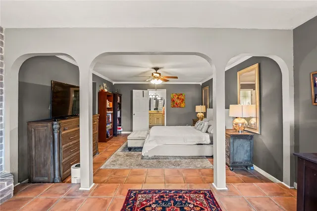 a bedroom with a bed and a flat tv screen on dresser