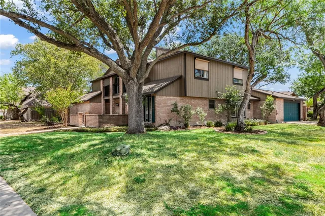 a house is sitting in middle od the grass