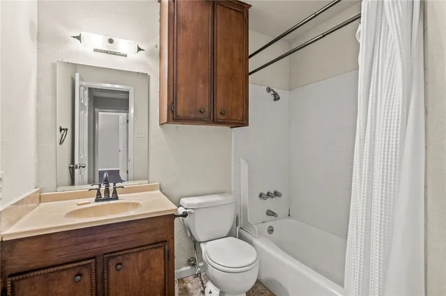 a bathroom with a granite countertop sink a toilet and shower