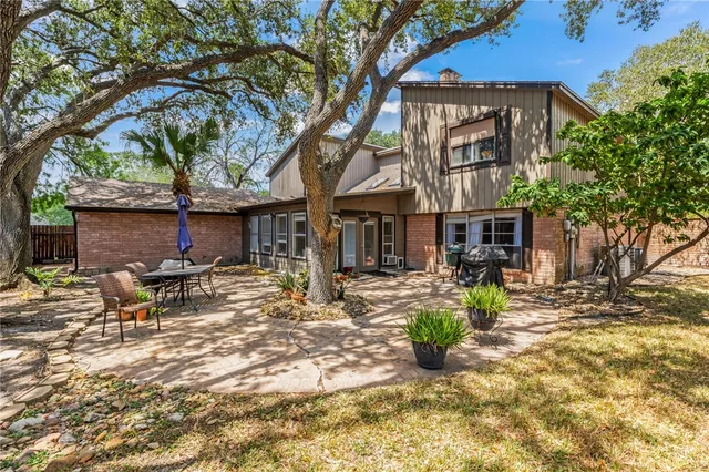 a backyard of a house with fire pit and trees