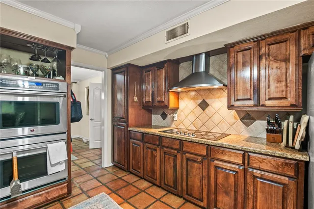 a kitchen with stainless steel appliances granite countertop a stove a sink and a microwave