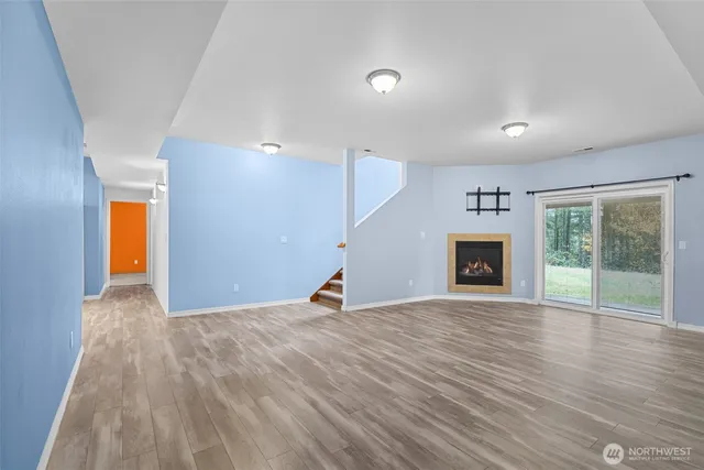 a view of empty room with wooden floor and fireplace