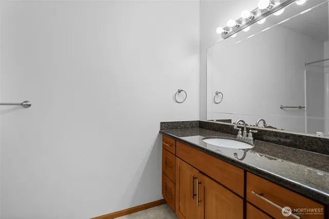 a bathroom with a granite countertop sink and a mirror