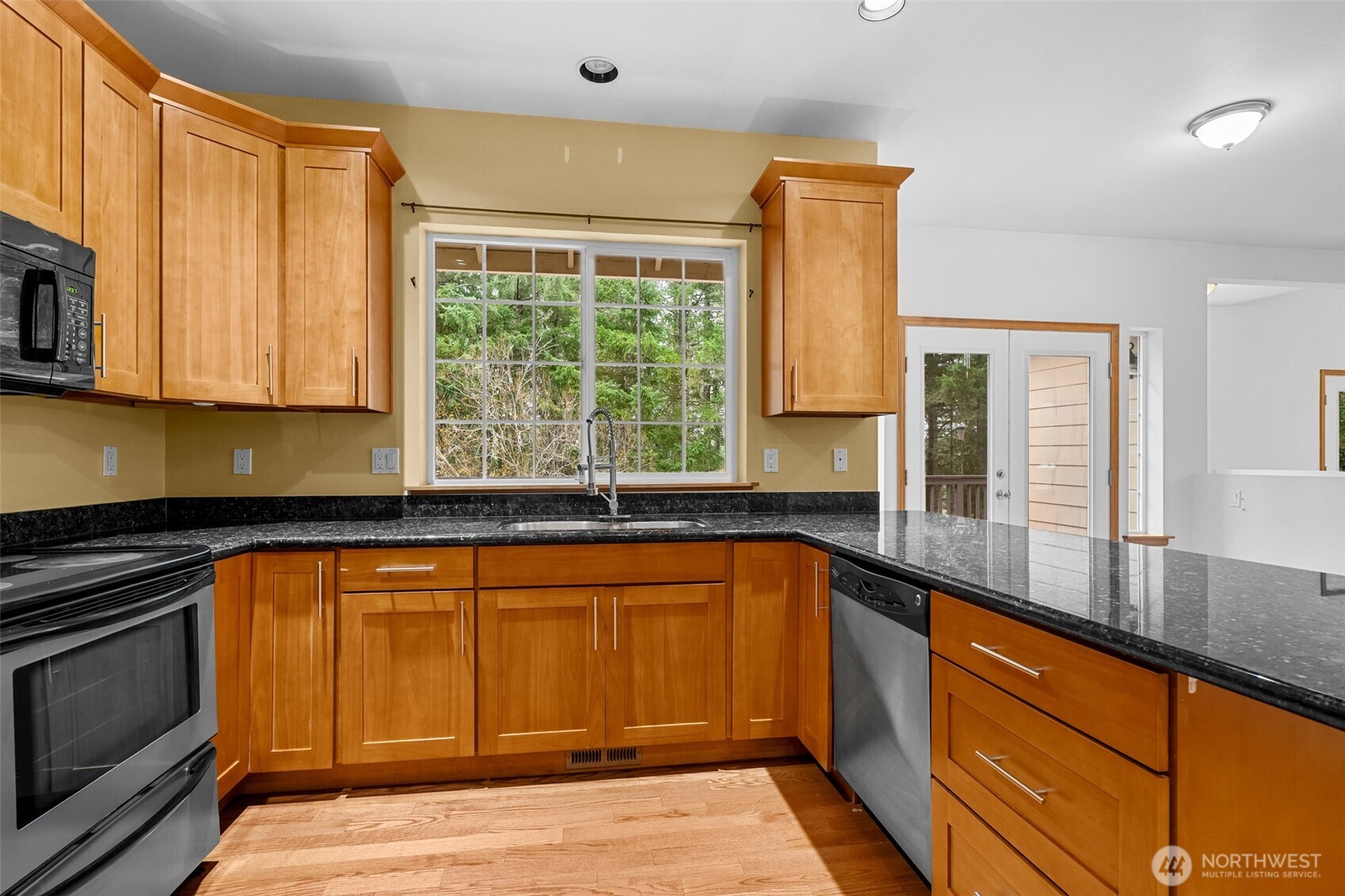 2311 202nd Avenue Southwest Lakebay, WA 98349 - Photo 10 of 39 a kitchen with granite countertop wooden cabinets stainless steel appliances a sink and a window