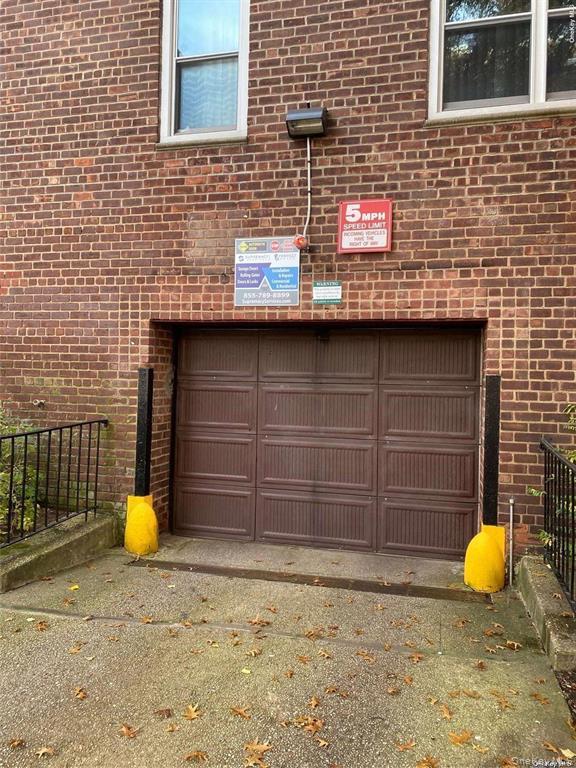 34-10 75th Street, Unit 3L Queens, NY 11372 - Photo 14 of 18 Garage featuring asphalt driveway and fence