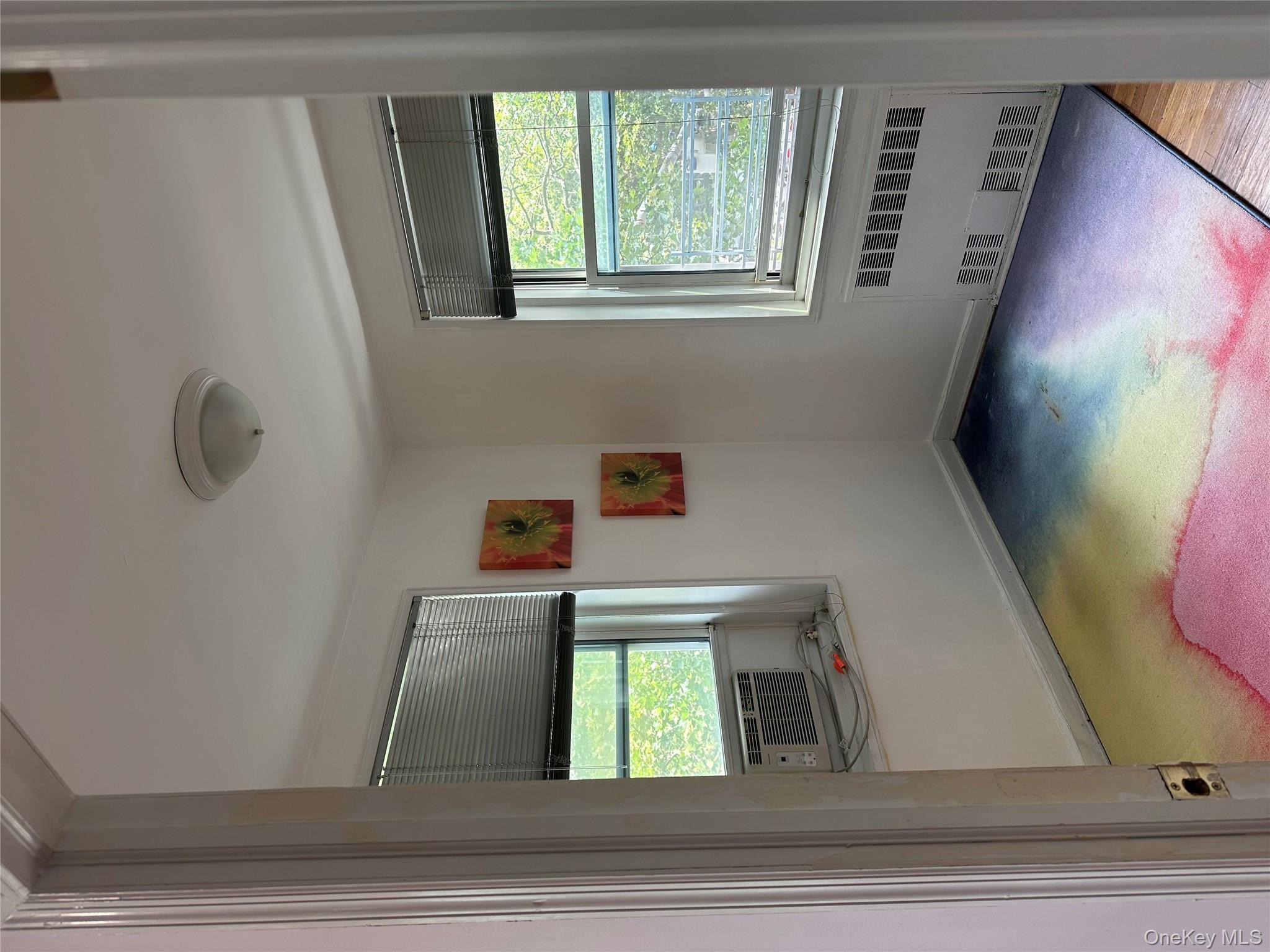 34-10 75th Street, Unit 3L Queens, NY 11372 - Photo 10 of 18 Empty room with radiator heating unit and cooling unit