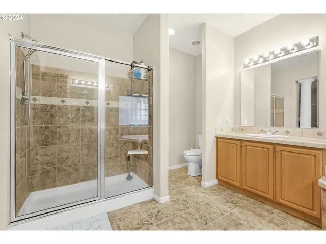 a bathroom with a double vanity sink toilet and shower