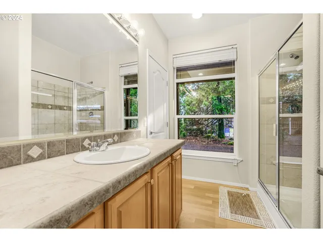 a bathroom with a granite countertop sink and a large mirror