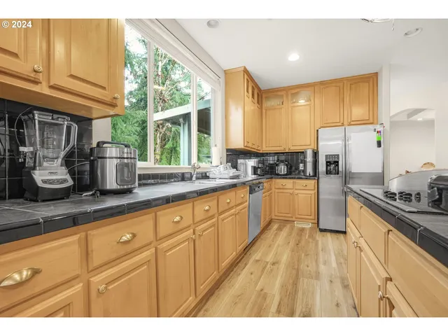 a kitchen with kitchen island granite countertop a sink appliances cabinets and a counter top space
