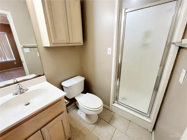 a bathroom with a sink a toilet a mirror and shower