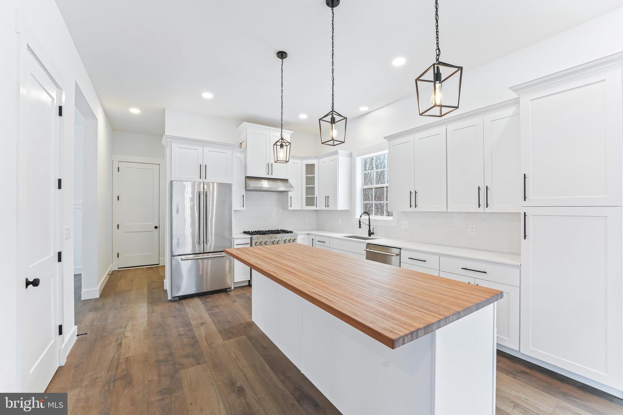 179 Ellicott Road Avondale, PA 19311 - Photo 32 of 56 a kitchen with stainless steel appliances granite countertop a sink a stove a refrigerator and island