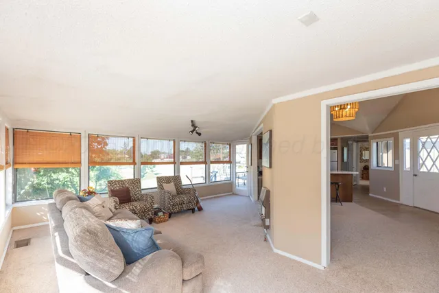 a living room with furniture and large windows