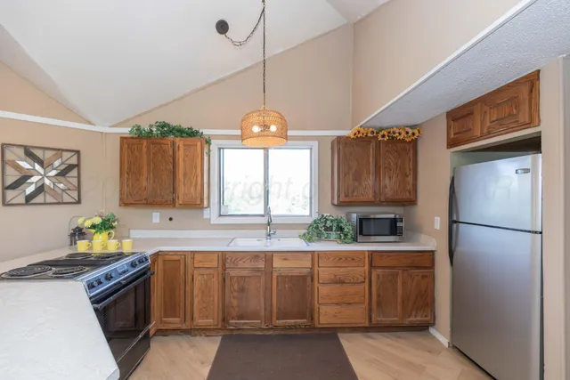 a kitchen with a refrigerator a stove a sink and a window