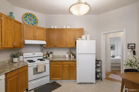 a kitchen with a white stove top oven and refrigerator