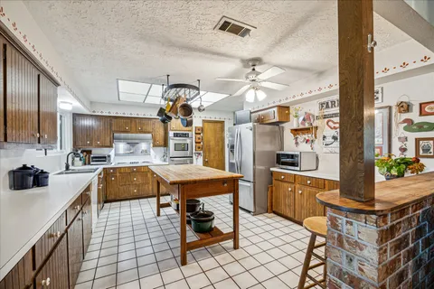a kitchen with stainless steel appliances kitchen island granite countertop a sink and cabinets