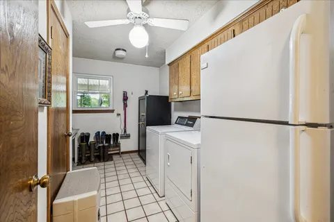 a kitchen with a refrigerator a stove cabinets dining table and chairs