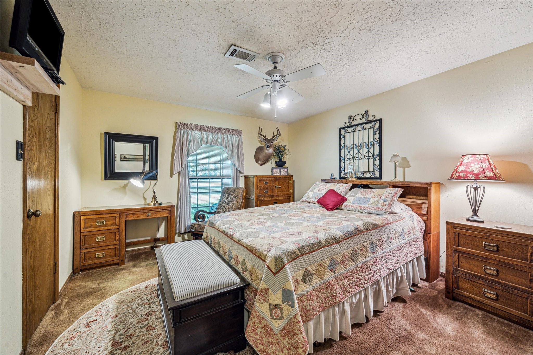 17814 Seidel Cemetary Road Tomball, TX 77377 - Photo 19 of 30 a bedroom with a bed and dresser with mirror