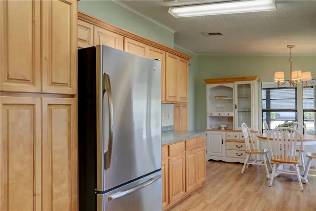 a kitchen with stainless steel appliances a refrigerator and wooden floor