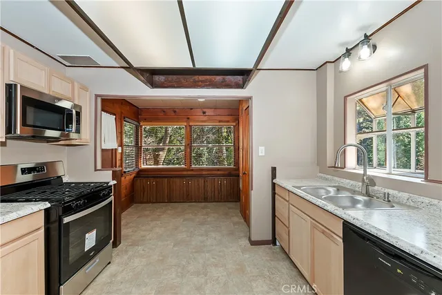 a kitchen with granite countertop a stove sink and microwave
